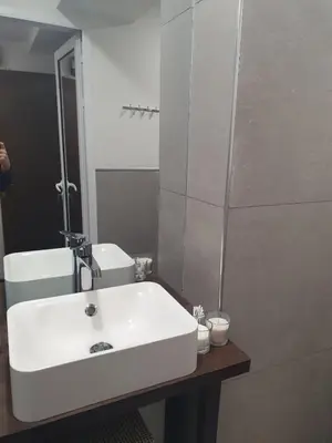 a bathroom with a white sink and a mirror at The white apartment at the ski in Bansko