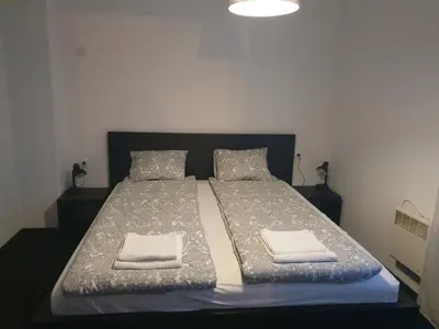 a bedroom with a bed with two towels on it at The white apartment at the ski in Bansko