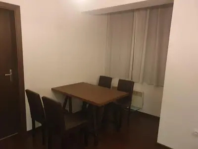 a dining room table and chairs in a room at The white apartment at the ski in Bansko
