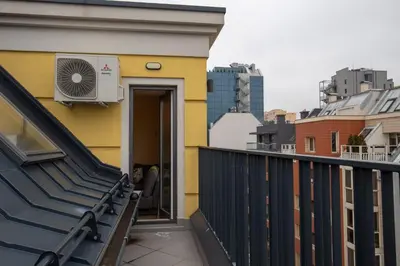a balcony of a yellow building with a fan at Apartment City View 2 in Sofia