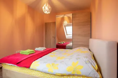 a bedroom with a bed with a red blanket and a mirror at Apartment City View 2 in Sofia