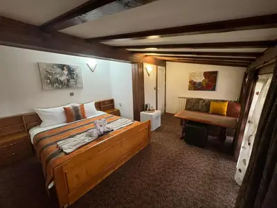 a bedroom with a large bed and a chair at Guest House Ivan in Bansko
