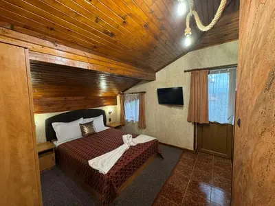 a bedroom with a bed in a wooden room at Guest House Ivan in Bansko