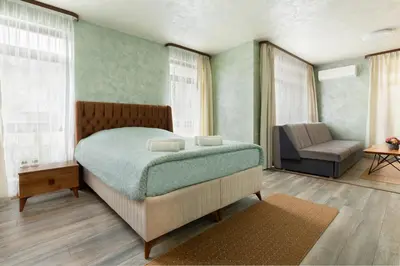 a bedroom with a bed and a chair and windows at Къща за гости
