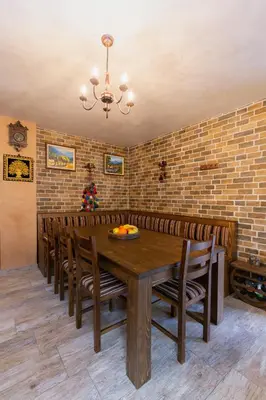 a dining room with a wooden table and chairs at Къща за гости