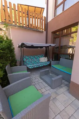 a patio with chairs and a table and a umbrella at Къща за гости