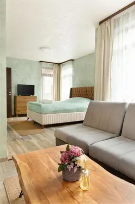 a living room with a couch and a bed at Къща за гости