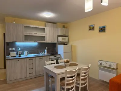 a kitchen with a table and chairs in a room at Апартамент Liora in Smolyan