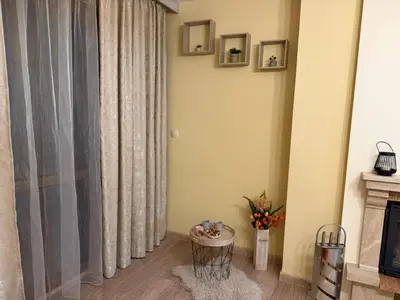 a living room with a curtain and a fireplace at Апартамент Liora in Smolyan