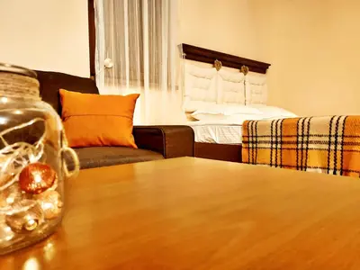 a living room with a table and a couch at Приказното място - The Fairytale Place in Smolyan