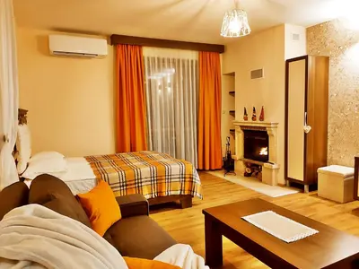 a living room with a couch and a fireplace at Приказното място - The Fairytale Place in Smolyan