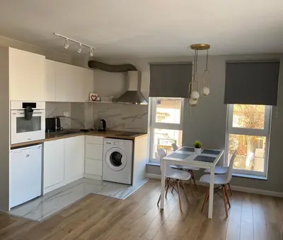 a kitchen with a table and a dining room at TheHouse - Apartment Kamenitza in Velingrad