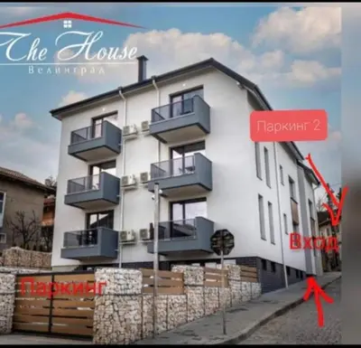 a large white building with balconies and a red sign at TheHouse - Apartment Kamenitza in Velingrad