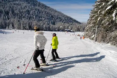 two people on skis in the snow on a ski slope at Hotel Malyovitsa in Govedartsi