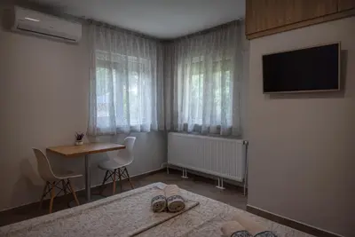 a bedroom with a table and a television and a table and chairs at Къща за гости Фолис in Kyustendil