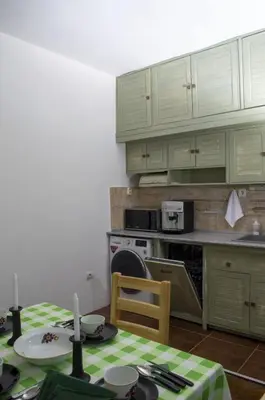 a kitchen with green cabinets and a table with a tablecloth at Midtown Place Apartment DORIS 1 with garage in Plovdiv
