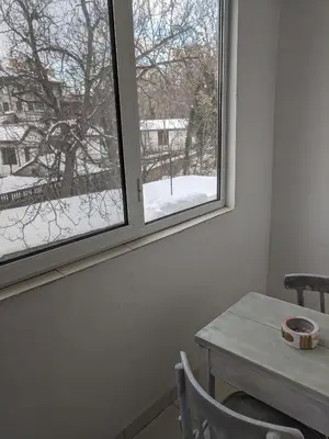 a room with a table and a window with snow outside at Midtown Place Apartment DORIS 1 with garage in Plovdiv