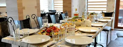 a table with plates and bowls of food on it at Хотел Дива in Blagoevgrad