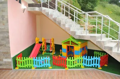 a play set under a stairs with a playground at Хотел Дива in Blagoevgrad