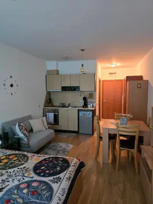 a living room with a couch and a table and a kitchen at Aspen Valley in Razlog