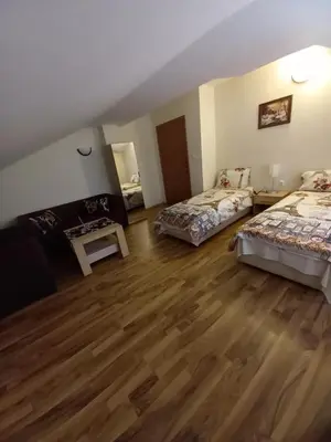 a room with two beds and a wooden floor at Guest rooms Bansko in Bansko