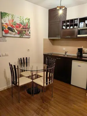 a kitchen and dining room with a glass table and chairs at Bansko Royal Towers - Studio 945 in Bansko