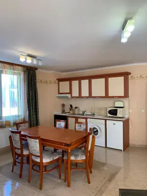 a kitchen and dining room with a wooden table and chairs at апартамент Манастира 1 in Pamporovo
