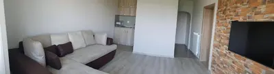 a living room with a couch and a television at Апартаменти Гювийски in Sapareva Banya