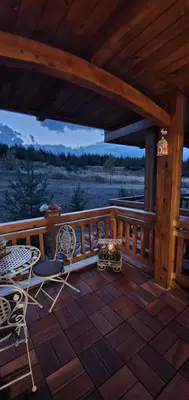 a wooden deck with chairs and a table on it at Луксозно студио в Банско - малко кътче от рая. in Bansko