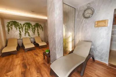 a waiting room with chairs and a clock on a wall at Family Hotel The View & SPA in Tsigov Chark