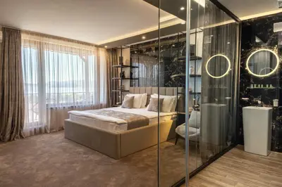 a bedroom with a bed and a glass wall at Family Hotel The View & SPA in Tsigov Chark