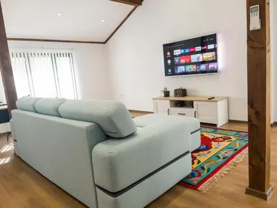 a living room with a couch and a flat screen tv at Stylish loft studio with great view to Ardino in Ardino