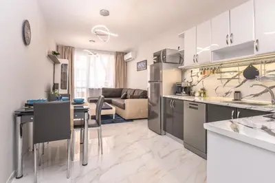 a kitchen and a living room with a couch at Stylish Residential Flat - with Parking & Balcony by Flat Mаnager in Sofia