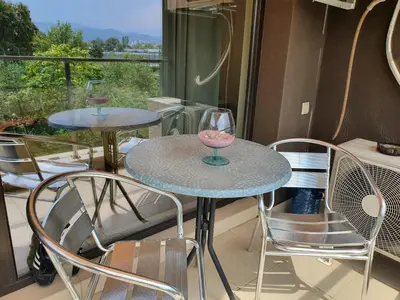 two tables and chairs on a balcony with a window at New Apartment at a Great Location in Blagoevgrad