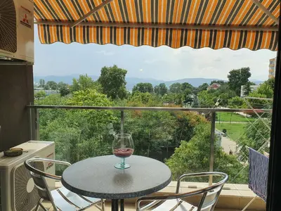 a glass of wine sitting on a table on a balcony at New Apartment at a Great Location in Blagoevgrad