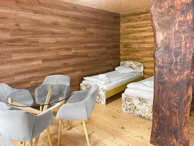 a room with chairs and a table and two beds at Власовъ in Pamporovo