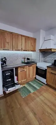 a kitchen with wooden cabinets and a stove top oven at апартамент Гигови in Bansko