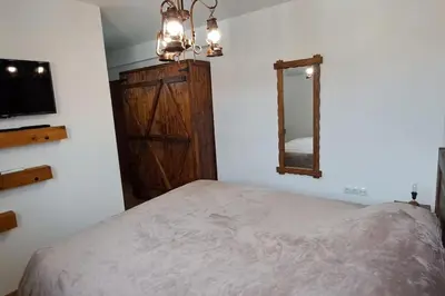 a bedroom with a bed and a dresser and a mirror at апартамент Гигови in Bansko