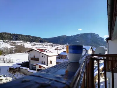 a coffee cup sitting on the ledge of a balcony at Cosy Apartment with terrace Eagle Rock in Beli Iskar