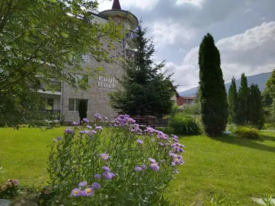 a garden with flowers in front of a building at Cosy Apartment with terrace Eagle Rock in Beli Iskar