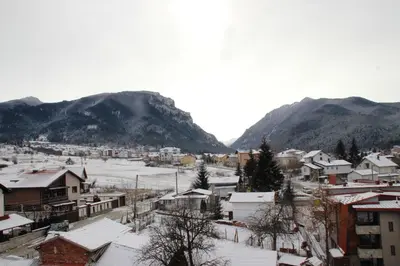 a town covered in snow with mountains in the background at Cosy Apartment with terrace Eagle Rock in Beli Iskar