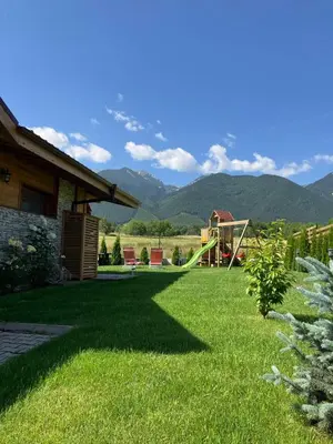 a yard with a playground with mountains in the background at Mountain villa Jordan- with JACUZZI in Razlog