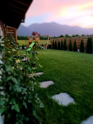 a green yard with stepping stones in the grass at Mountain villa Jordan- with JACUZZI in Razlog