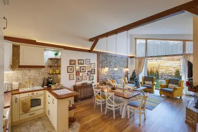 a kitchen and living room with a table and chairs at Mountain villa Jordan- with JACUZZI in Razlog