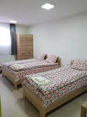 two beds sitting next to each other in a bedroom at Семеен Хотел-