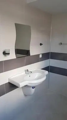 a bathroom with a white sink and a mirror at Семеен Хотел-