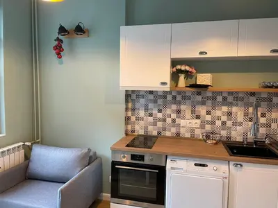 a kitchen with a chair and a stove and cabinets at Solunska Stylish Apartment in Sofia