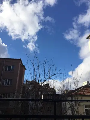 a blue sky with some clouds and some buildings at Solunska Stylish Apartment in Sofia