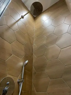 a shower with a tiled wall in a bathroom at Solunska Stylish Apartment in Sofia