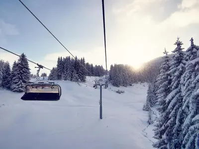 a ski lift in the snow with snow covered trees at Grand Monastery Violet Apartment With One Bedroom And A Terrace in Pamporovo